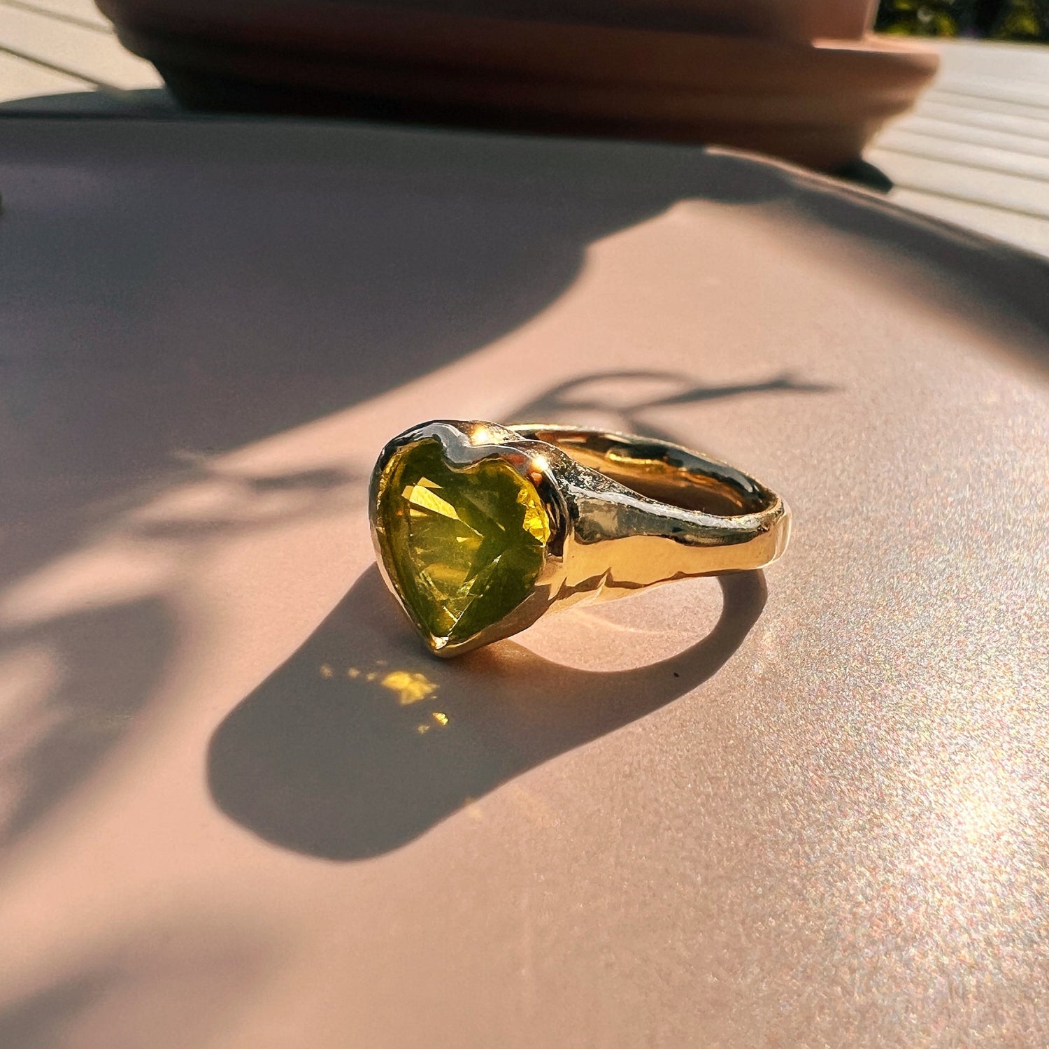 Unser Hey Amour Herz Ring ist aus 8 Karat Gelbgold. Der Edelstein ist ein Peridot. Handgefertigt in Berlin.